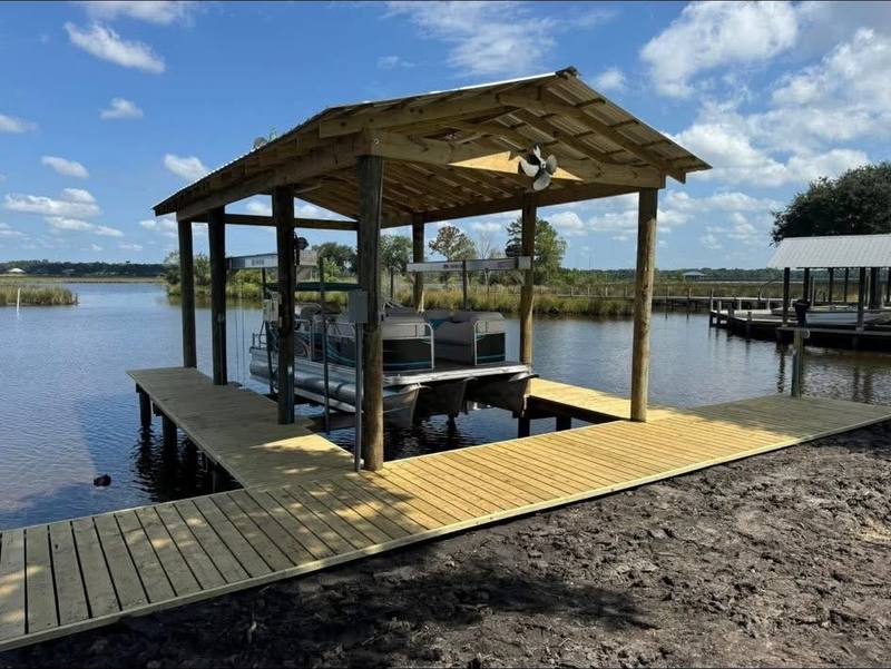Boathouse at the end of a long pier on a wide bayou